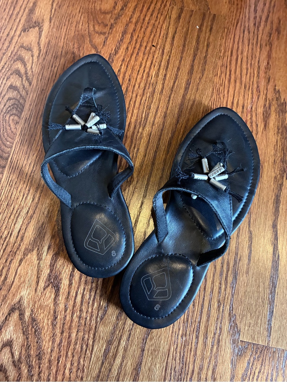 Women's Reef Black Thong Sandals with silver embellishments.
